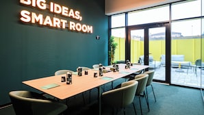 A conference room with a long table, chairs, and a neon sign reading "BIG IDEAS, SMART ROOM". - CX Modena Crocetta (Modena)