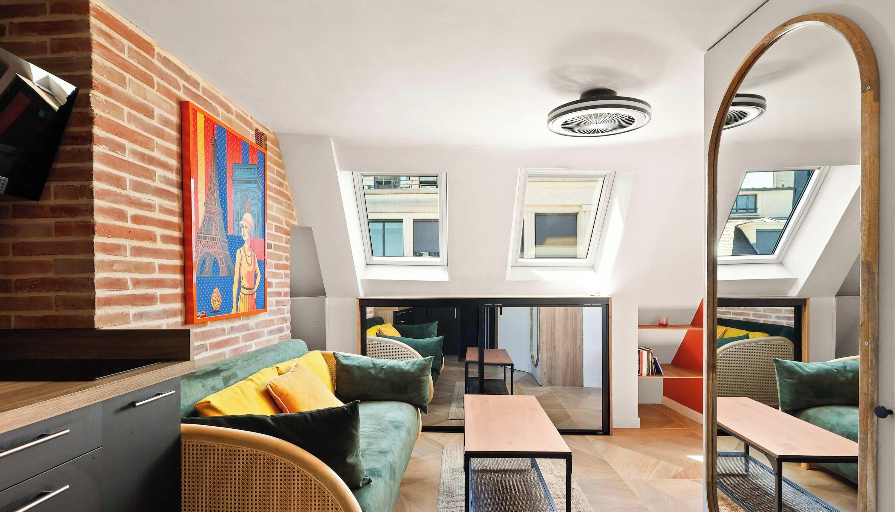Een moderne woonkamer met een bakstenen muur, een grote spiegel en een loft-plafond.