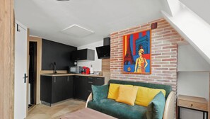 A modern kitchen with black cabinets, a microwave, and a red coffee maker.