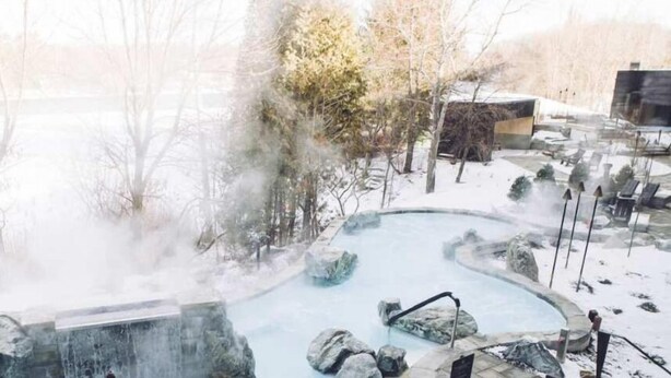 A hot spring area with a pool, rocks, and steam rising from the water. - Spa Retreat with Jay Peak Views (Mansonville)