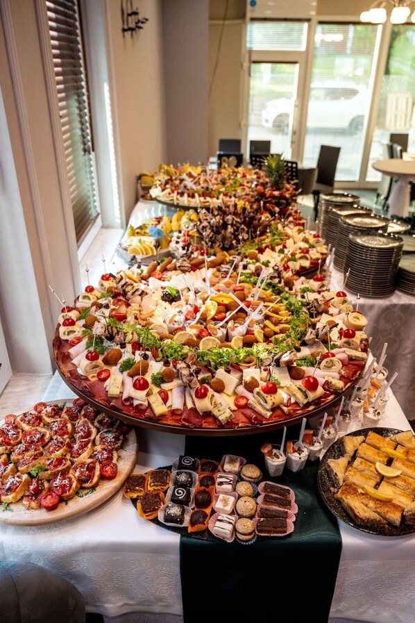 Ein reichhaltiges Buffet mit verschiedenen Speisen, darunter Käse, Fleisch und Desserts.