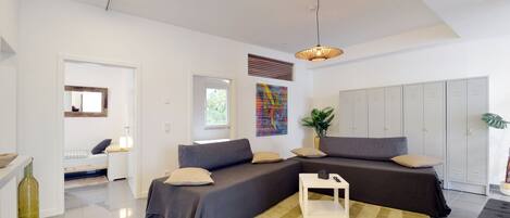 A modern living room with a sectional sofa, a small white table, and a large window.