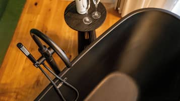 A black bathtub with a faucet and a control knob.
