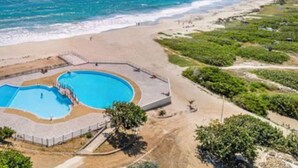 A coastal hotel with a large swimming pool, beachfront access, and a view of the ocean. - Serenity   Wonderful sea view   studio 4p (SAINT MARTIN)
