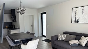 A modern living space with a dining area, a sofa, and a coffee table. - Modern Apartment in Ravensburg (Ravensburg)