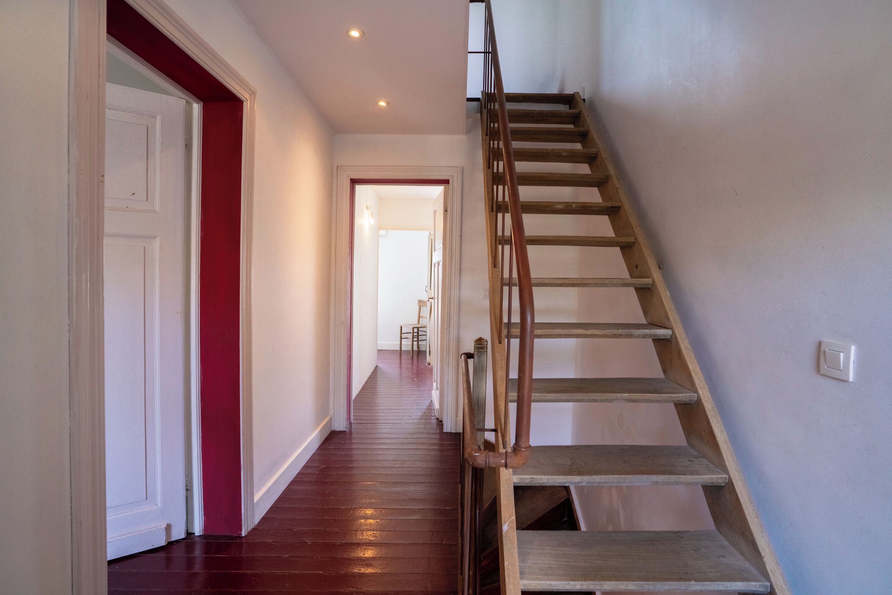 A staircase with wooden steps and metal railings leading to an upper floor.