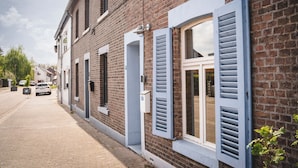 Una hilera de casas de ladrillo con contraventanas azules y una calle empedrada.