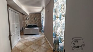 Quarto com cama, guarda-roupa e parede com padrão de plantas.