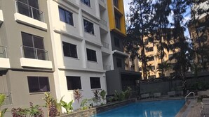 A swimming pool with a metal ladder, surrounded by a tiled deck and plants. - Chic studio with WiFi and AC in serene Nairobi (Nairobi)