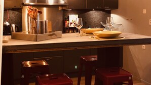 Una cocina moderna con una isla central, electrodomésticos de acero inoxidable y taburetes de bar.