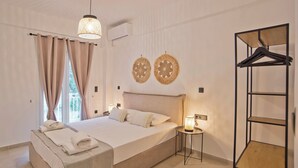 Een slaapkamer met een bed, nachtkastje, hanglamp, airconditioning en een kledingkast.