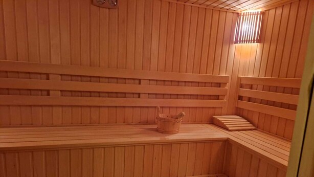 A wooden sauna with benches and a small window. - Arena Hotel Tartar (Tartar)