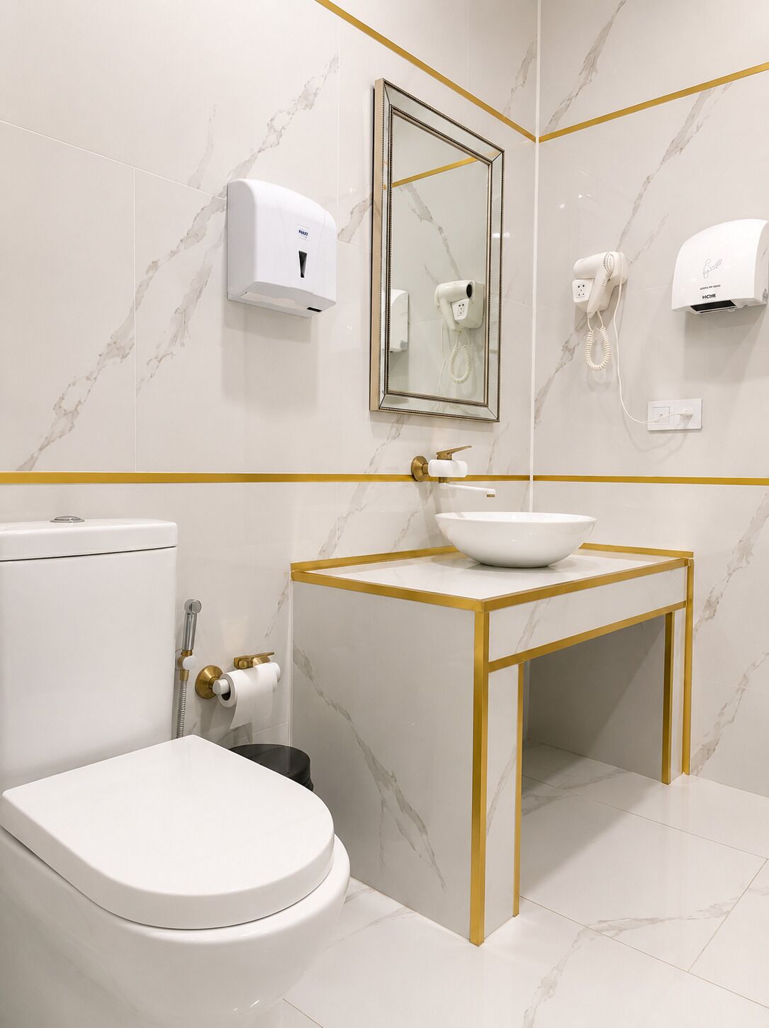 Un baño moderno con inodoro, lavamanos y espejo.