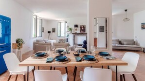 Un salon moderne avec un coin repas aménagé pour accueillir six personnes.