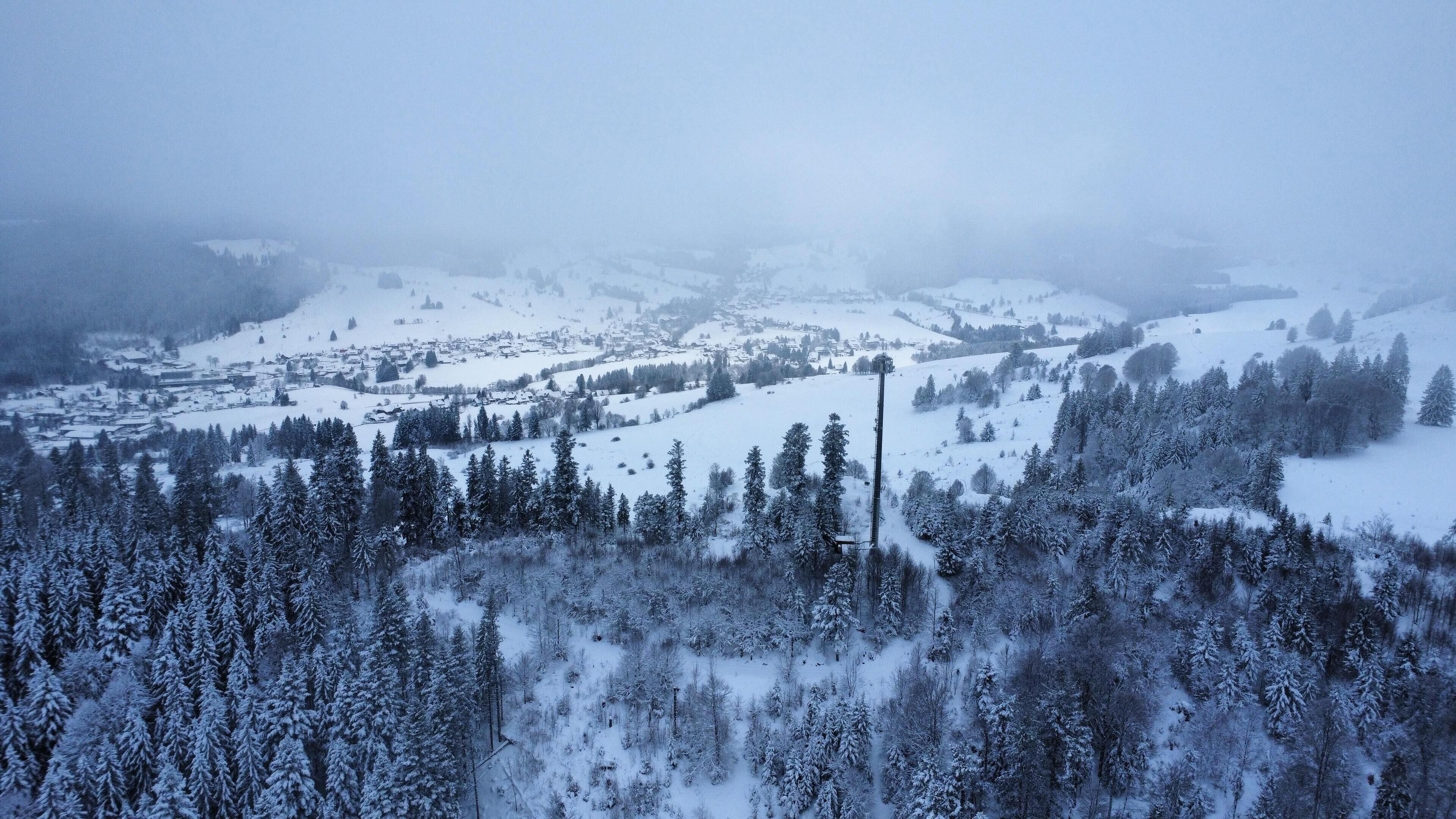 A snowy mountain landscape with a village in the valley.