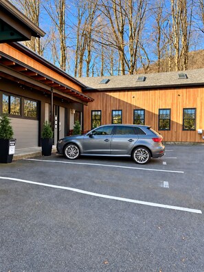 Un edificio moderno con un automóvil estacionado frente a él.