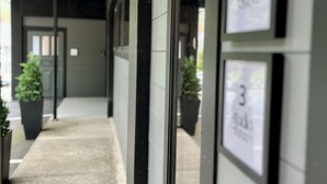 A hallway with numbered signs indicating room numbers 2 and 3, potted plants, and a concrete floor.