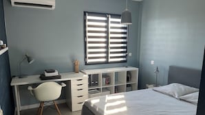 A bedroom with a bed, a desk with a chair, a window with blinds, and a bedside lamp. - Beautiful contemporary house for 8 people (Lattes)
