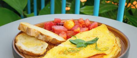 Un plato de comida con tostadas, huevos y fruta sobre una mesa.