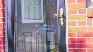 Una puerta cerrada con un panel de vidrio, un picaporte de latón y una ventana encima.