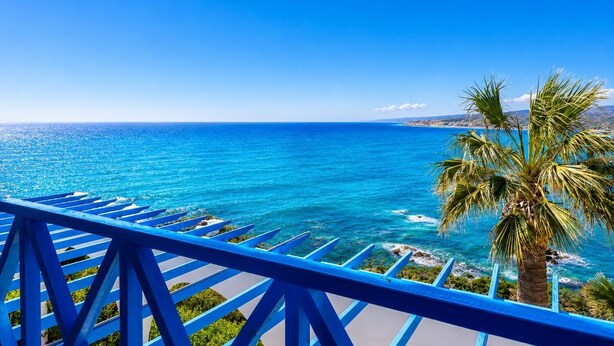 A balcony with a view of the sea, a palm tree, and a blue railing. - Panorama Villa - Four Bedroom Villa, Sleeps 8 (Pomos)