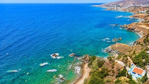 A coastal landscape with clear blue waters, rocky outcrops, and a path leading to a building with a red roof. - Panorama Villa - Four Bedroom Villa, Sleeps 8 (Pomos)