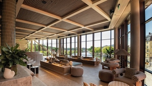 A spacious lobby with large windows, a central seating area, and a modern ceiling design. - The Dock (Södertälje)