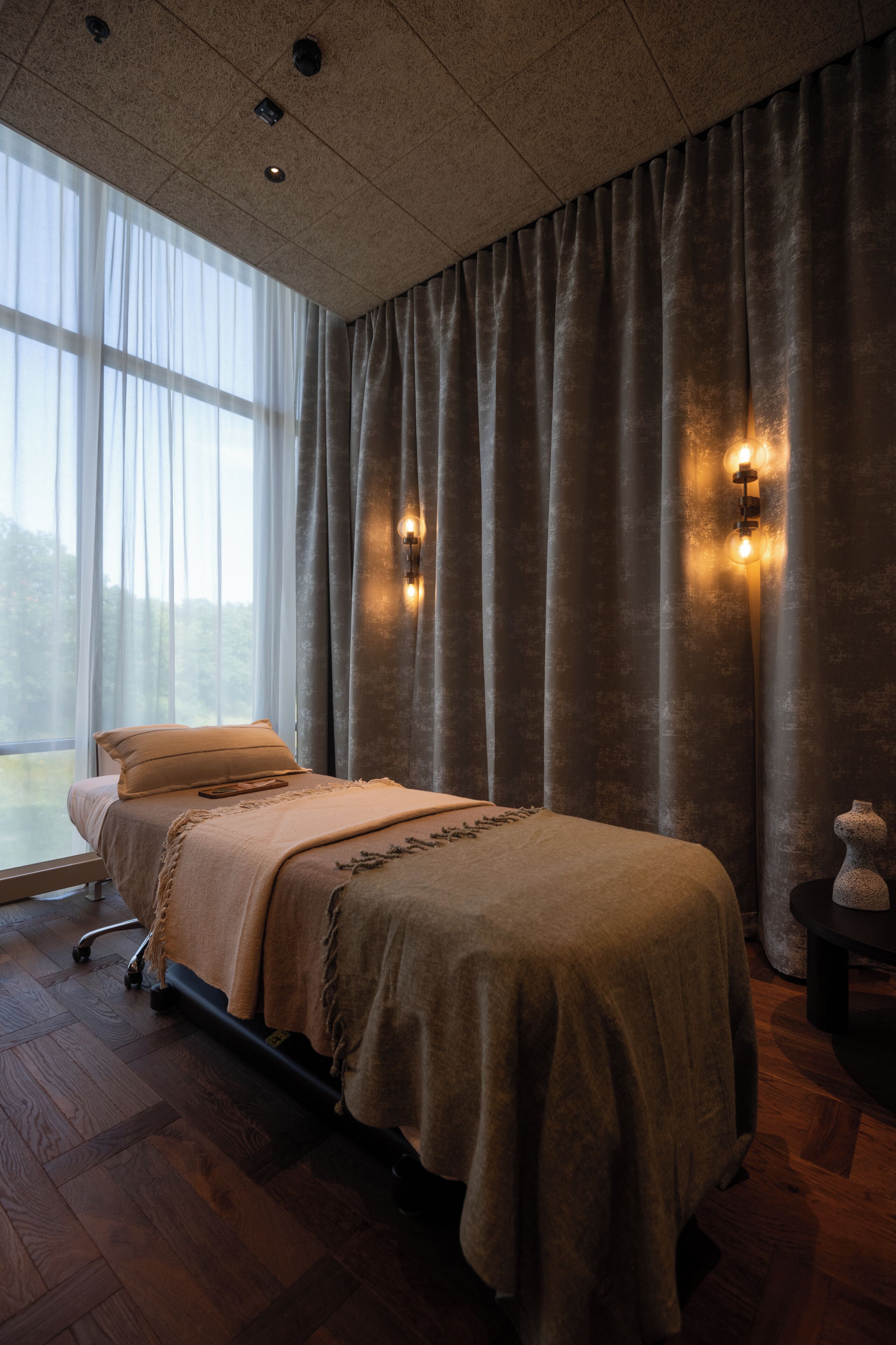 A room with a bed, a window, and curtains.