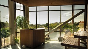 A modern interior with large windows, a wooden bench, and a planter. - The Dock (Södertälje)