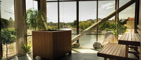 Un intérieur moderne avec de grandes fenêtres, un banc en bois et un jardinier.