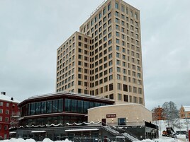 A multi-story hotel with a modern design, featuring a prominent staircase leading to the entrance.