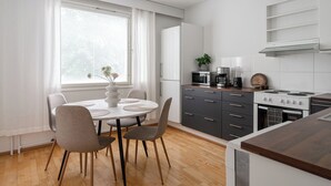 Una cocina moderna con comedor, que incluye una mesa redonda, sillas, refrigerador, estufa y alacenas.