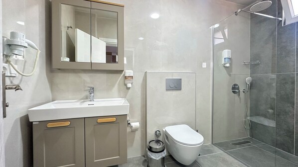 A modern bathroom with a sink, mirror, toilet, and shower. - Azak Blue Otel (Alanya)