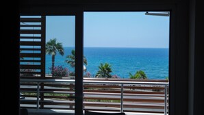 A balcony with a view of the ocean and palm trees. - Azak Blue Otel (Alanya)