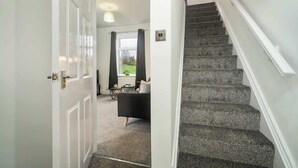 Un escalier menant à un espace de vie offrant une vue sur l’extérieur.