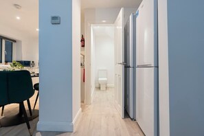 Een moderne keuken met een eethoek, een wit toilet en een gang naar een slaapkamer.
