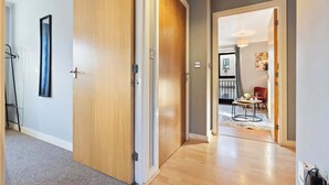 Ein Flur mit Holztüren, der zu einem Essbereich mit Tisch und Stühlen führt.