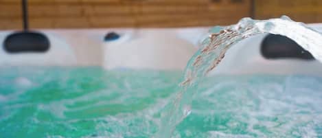 A hot tub with water being poured into it.