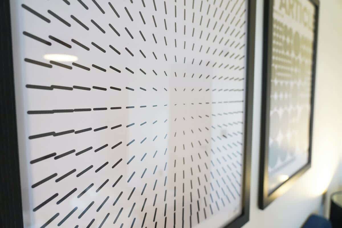 A wall with a geometric pattern of black and white lines.