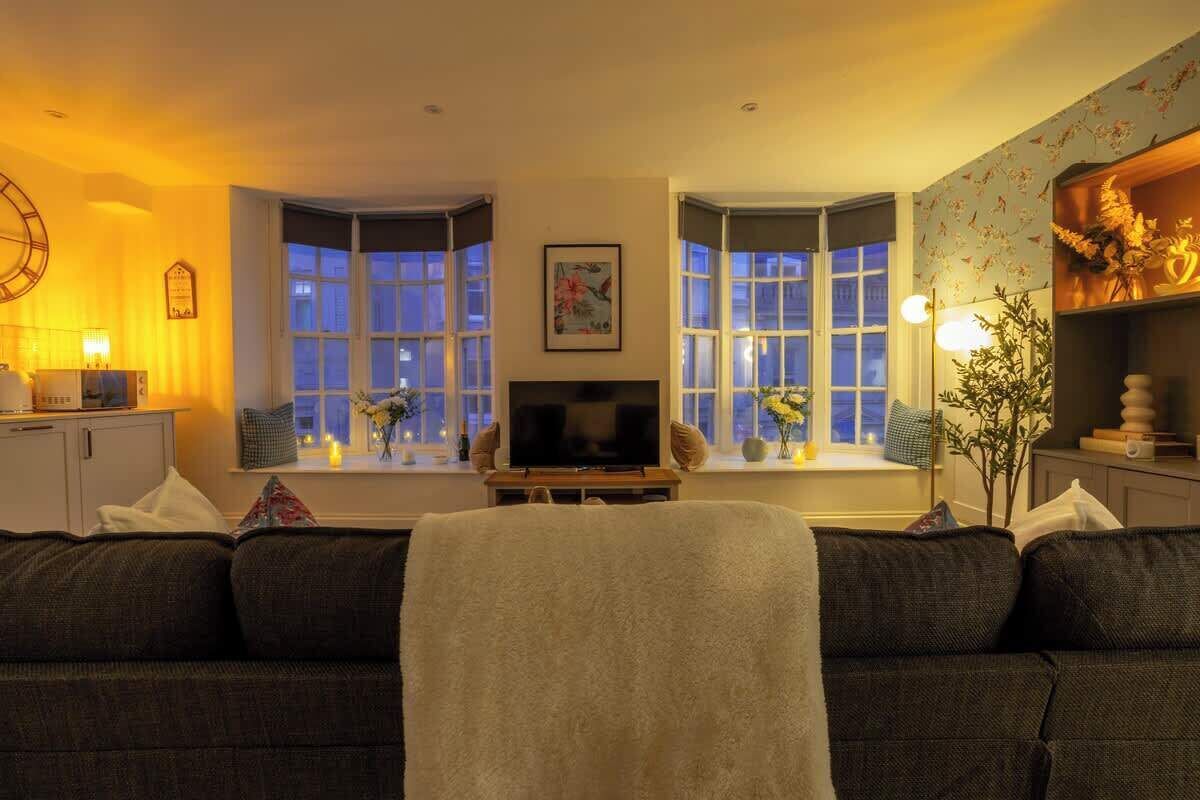 Una sala de estar acogedora con un sofá, un televisor y objetos decorativos.