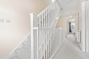 Un escalier avec des rampes blanches menant à un palier.
