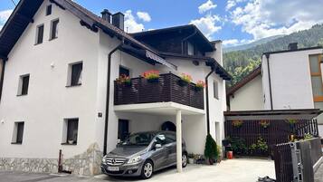 A two-story house with a car parked in the driveway.