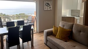 Una sala de estar moderna con balcón, comedor y cocina.