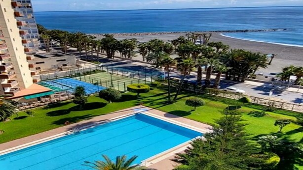 Un hotel con piscina, playa y vista al océano.