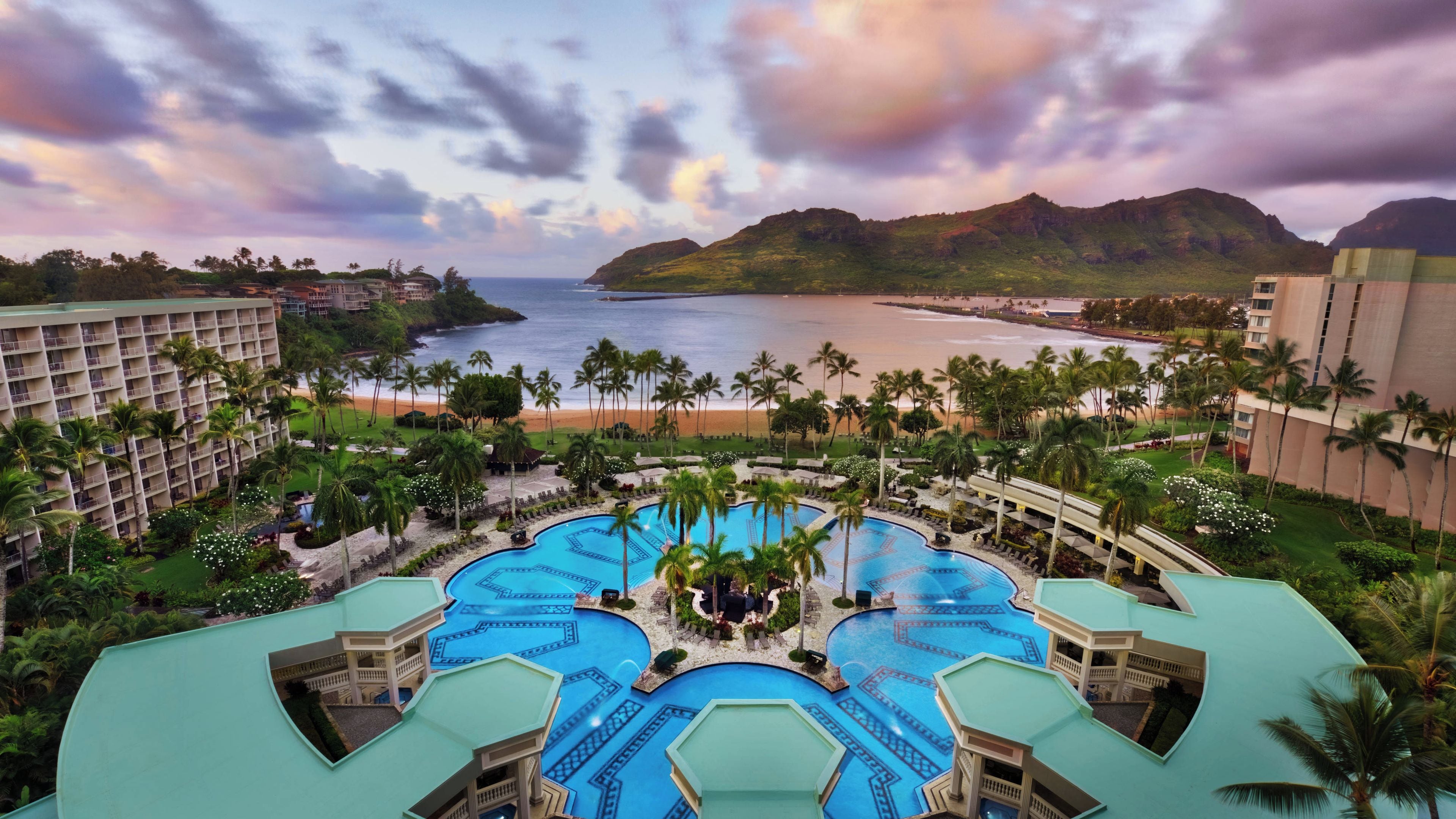 Ein Resort mit mehreren Pools, einem Strand und Palmen.