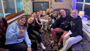 A group of people sitting on a couch in a room with a stone wall, a television, and decorative items. - PEMBROKE HOTEL (Blackpool)