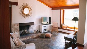A cozy living room with a fireplace, a television, and comfortable seating. - Santa Sofia. Casa com 4 quartos e Jardim Espaçoso em Moledo (Moledo)
