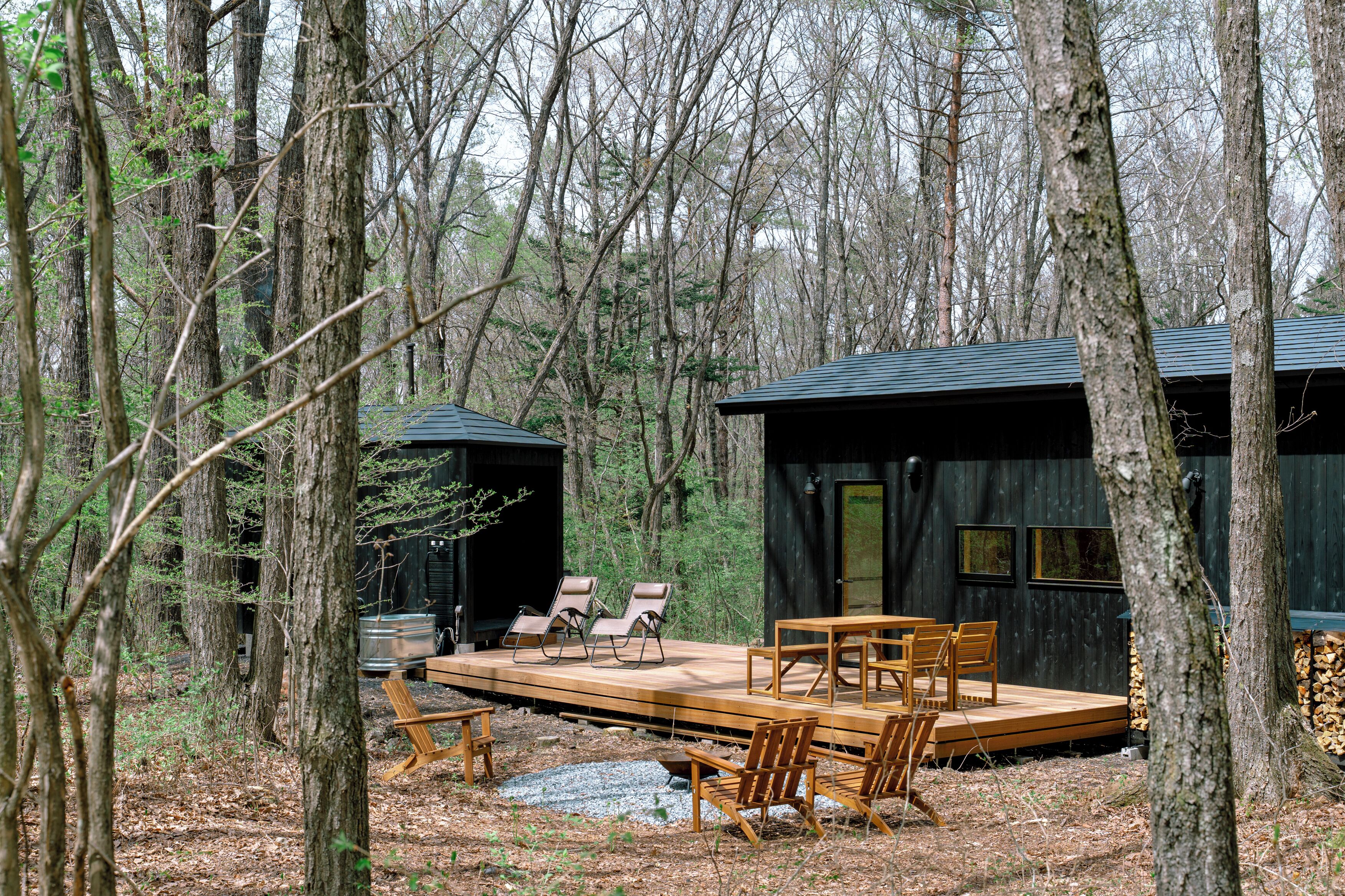 Une cabane dotée d’une terrasse en bois, d’un coin salon et d’un espace extérieur abrité.