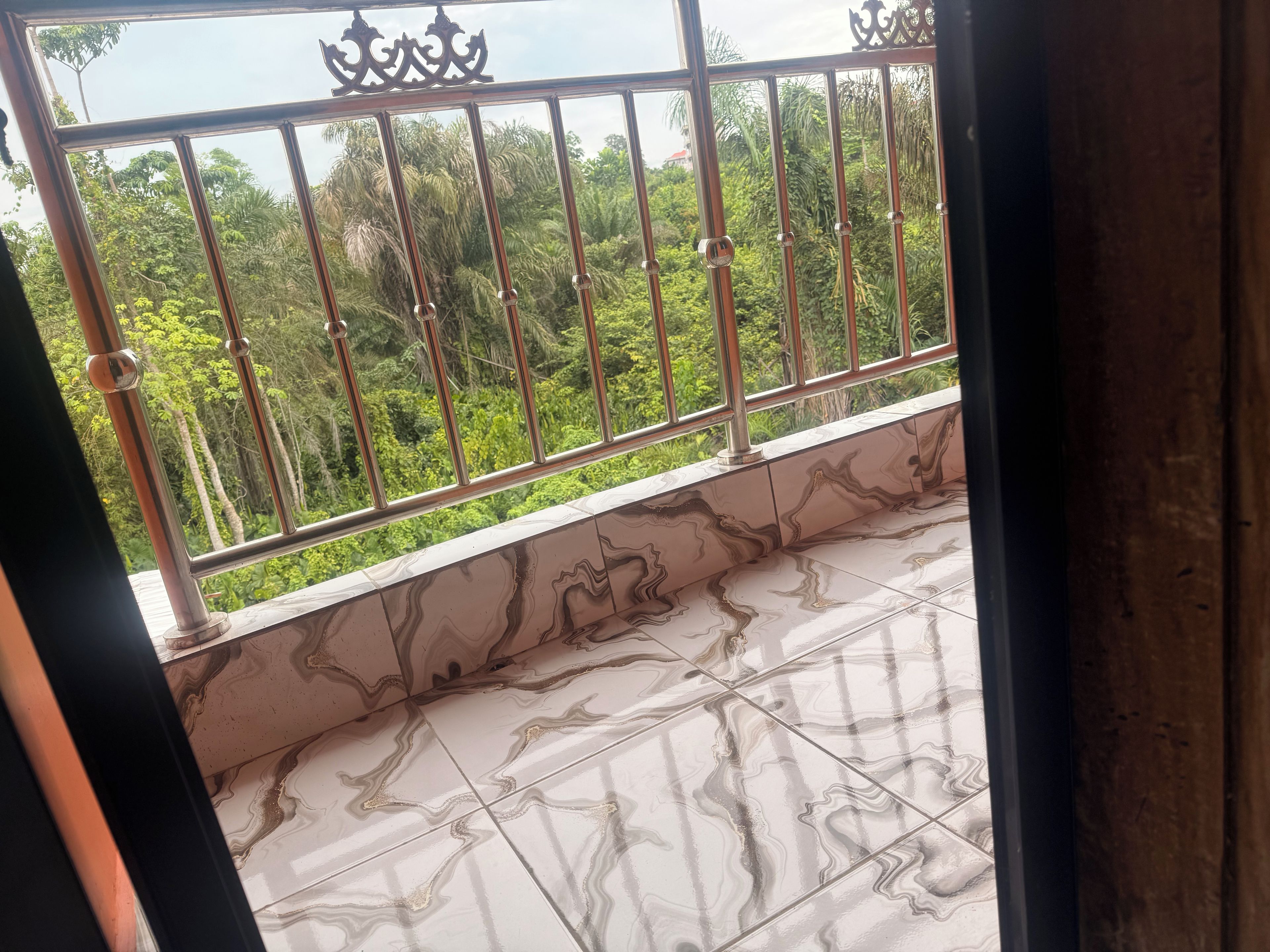 Ein Balkon mit Metallgeländern und Blick auf üppiges Grün.