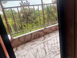 Ein Balkon mit Metallgeländern und Blick auf üppiges Grün.